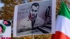 FILE - A demonstrator holds a placard bearing the portrait of rapper Toomaj Salehi, who was arrested after protests in Iran, during a rally in Istanbul, Turkey, Nov. 26, 2022. Salehi, who had been released on bail, has been arrested again, Iranian media reported on Nov. 30, 2023.
