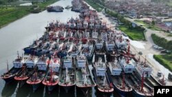 ২০২৩ সালের ২৬ জুলাই তোলা ছবিতে দেখা যাচ্ছে, চীনের পূর্ব দিকে জিয়াংসু প্রদেশে ঘূর্ণিঝড় ডকসুরি আসার প্রস্তুতি হিসেবে মাছ ধরা নৌকাগুলি একটি বন্দরে আটকে রয়েছে।