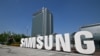 FILE - A worker waters the flower garden next to the logo of Samsung Electronics at the company's headquarters in Suwon on June 13, 2023. 