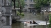 Volunteers in boats assist during an evacuation from a flooded area in Kherson, Ukraine, June 8, 2023, following damage sustained at the Kakhovka hydroelectric power plant dam.