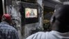 Watu wakimtazama rais Macky Sall wakati wa mkutano na waandishi wa habari uliotangazwa moja kwa moja na televisheni ya taifa . Picha na Michele Cattani / AFP