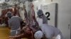 Tukang daging memotong daging buruan saat bangkai digantung di rumah potong hewan di Bela Bela, pada 22 April 2024. (Foto: AFP/Marco Longari)