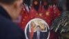 FILE - A man looks at a decorative plate featuring an image of Chinese President Xi Jinping at a souvenir store next to Tiananmen Square in Beijing on Feb. 27, 2018.