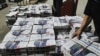 FILE - An employee loads freshly printed packages of the Le Monde daily newspaper at a printing facility in Saint-Vulbas, eastern France, April 20, 2023. 