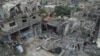 Palestinians walk about buildings destroyed in the Israeli bombardment in the Nusseirat refugee camp in the Gaza Strip, Oct. 29, 2023. 