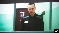 Russian opposition leader Alexei Navalny is seen on a TV screen as he appears in a video provided by the Russian Federal Penitentiary Service in Melekhovo, Vladimir region, during a hearing at the Russian Supreme Court in Moscow, June 22, 2023. 