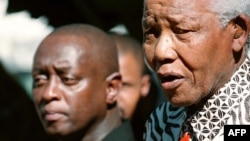 FILE - Former South African president Nelson Mandela, right, meets with playwright Mbongeni Ngema at Mandela's home in Johannesburg, June 17, 2002. 