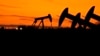 FILE - Oil Pump jacks work at dusk near Barnes City, Texas, Nov. 1, 2023. Major fossil fuel-producing countries still plan to extract more than double the amount of fossil fuels in 2030.