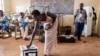A voter casts her ballot at a polling station at Bwakya school in Lubumbashi, Dec. 21, 2023.
