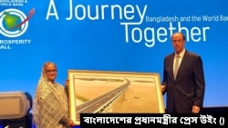 বিশ্বব্যাংক প্রেসিডেন্টের হাতে পদ্মা সেতুর ছবি তুলে দিলেন শেখ হাসিনা। ১ মে, ২০২৩। 