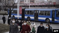 2024年3月25日，走在北韓平壤凱旋門附近的一條街道上的人們。 (法新社照片)