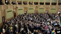 FILE - Poland's lawmakers vote in parliament, in Warsaw, May 26, 2023. 