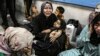 Palestinians wounded at Ahli Arab hospital sit at al-Shifa hospital, in Gaza City, Gaza Strip, Oct. 17, 2023. The Hamas-run Health Ministry says an Israeli airstrike caused an explosion, but the Israeli military says it was a misfired Palestinian rocket. 