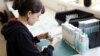 Production Executive Lilly Ellis puts labels on jars in Hove, Britain, April 18, 2023. Four-day work weeks improved Spanish workers' health by lowering stress, reducing fuel emissions, and benefiting children, a pilot program showed on Tuesday. 