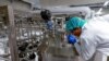 FILE - Founder & CEO Uma Valeti peers into one of the cultivation tanks at the Upside Foods plant, where lab-grown meat is cultivated, in Emeryville, California, Jan. 11, 2023.
