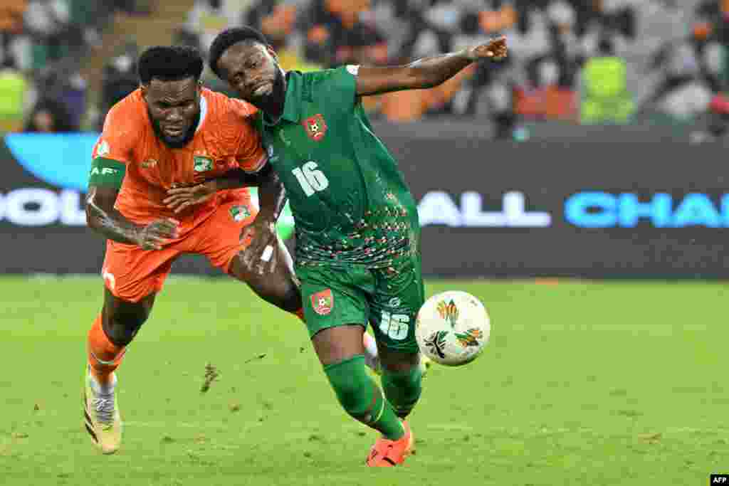 O médio #8 Franck Kessie da Costa do Marfim disputa a bola com o médio #16 Moreto Cassama da Guiné-Bissau durante o jogo de futebol do grupo A da Taça das Nações Africanas (CAN) 2024 em Abidjan, a 13 de janeiro de 2024. (Foto de Issouf SANOGO / AFP)