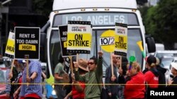 FILE - Hotel workers march and protest while a bus driver waits in traffic, as they continue their strike in Los Angeles, Oct. 25, 2023. 