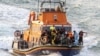 FILE - Rescue personnel bring migrants ashore after their boat sunk in the English Channel, near Dover, Britain, Aug. 12, 2023, in this photo obtained from social media. (Stuart Brock/via Reuters)