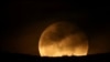 FILE - A full moon rises over Dajti Mountain in Tirana, Albania, March 25, 2024. 
