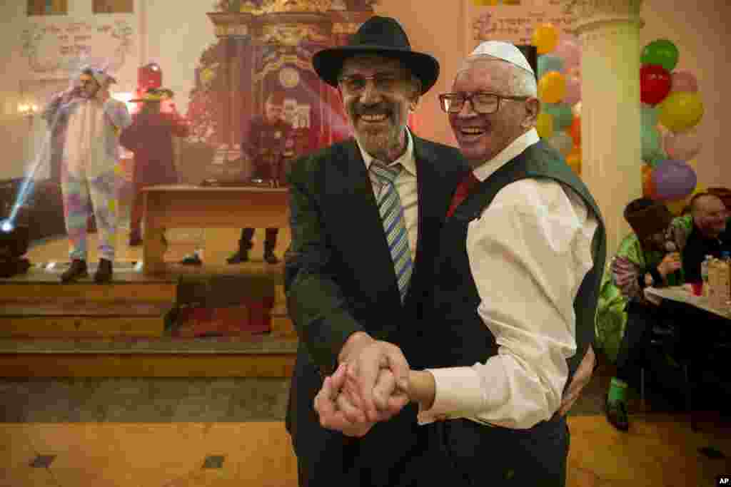 Hombres de la comunidad judía ucraniana bailan durante las celebraciones de Purim y una comida festiva en la Gran Sinagoga Coral en Kiev, Ucrania, el domingo 24 de marzo de 2024. Purim es ampliamente descrita como la celebración judía más alegre, celebrada con disfraces, parodias, sonajas, matracas y varios grados de alboroto. (Foto AP/Vadim Ghirda) 