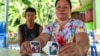 The parents of Natthaporn, who was working in Israel and has been abducted in the ongoing conflict between Israel and the Palestinian Islamist group Hamas, hold up his pictures at their house in Nakhon Phanom, Thailand, Oct. 10, 2023. 