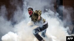 Mwandamanaji akitorokea gesi ya kutoa machozi, wakati wa maandamano ya Nairobi. 