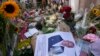 FILE - A photo and floral tributes mark the spot where journalist Peter R. de Vries was shot in Amsterdam, Netherlands, July 8, 2021.