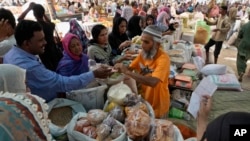 পাকিস্তানের করাচিতে প্রাদেশিক সরকার কর্তৃক প্রদত্ত মূল্যে পণ্য সরবরাহের জন্য একটি বাজারে মুদির জিনিসপত্র কিনছে লোকেরা। ১২ এপ্রিল, ২০২৩। 