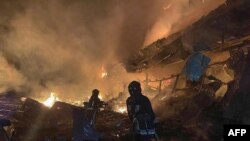 Picha iliyotolewa na Kitengo cha Huduma ya Dharura cha Ukraine Agosti 14, 2023, ikionyesha wafanyakazi wa uokoaji wakiendelea kupambana na moto kufuatia shambulizi la usiku liliofanywa na Russia huko Odesa. (Photo by Handout / Ukrainian Emergency Service / AFP) 