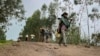 FILE — An unidentified armed militia fighter walks down a path as villagers flee, near the village of Chenna Teklehaymanot, Ethiopia, on Sept. 9, 2021. A human rights body reported on Dec.6, 2023, that more than 50 civilians were killed in attacks in Ethiopia in the past month.
