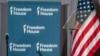 FILE - Freedom House logos are displayed on a panel behind a teleprompter next to a U.S. flag during the rights group's annual awards ceremony in Washington, May 9, 2023.