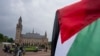 A demonstrator waves the Palestinian flag outside the Peace Palace housing the International Court of Justice in The Hague, Netherlands, May 24, 2024. The U.N. court ordered Israel to halt its military operations in Gaza.