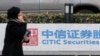 FILE - A woman walks past a signage for Citic Securities at its head office in Beijing, China, March 27, 2013. Xu Zuo, vice president at China Citic Group, is "suspected of serious disciplinary and legal violations," an inspection commission said Sunday.