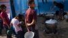 FILE — Palestinian children wait for food in a displaced tent camp in Khan Younis, southern Gaza Strip, Oct. 25, 2023. Even before the Israel-Hamas war broke out, Palestinians struggled to fulfill their basic needs, according to a Gallup poll. 