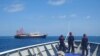 FILE - This handout photo taken Apr. 27, 2021 and received from the Philippine coast guard shows Philippine coast guard personnel aboard their ship BRP Cabra monitoring Chinese vessels anchored at Sabina Shoal, in the South China Sea. 