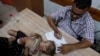 A Palestinian girl is examined by a doctor amid fears over the spread of polio after the first case was reported by the Ministry of Health, at Al-Aqsa Martyrs Hospital, in Deir Al-Balah in the central Gaza Strip, Aug. 18, 2024. 
