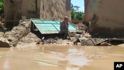 আফগানিস্তানের বাঘলান প্রদেশে ভারী বন্যার পরে একজন ব্যক্তি তার ক্ষতিগ্রস্ত বাড়ির সামনে বসে আছেন। ১২ মে, ২০২৪। 