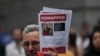 A man holds a picture of Gad Haggai and Judith Lynne Weinstein, who were kidnapped from Israel on October 7, during a rally in New York, Oct. 26, 2023. Haggai was killed on the day of the attack, his kibbutz community said Friday. 