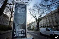 A van displaying a protest banner is parked outside the Covid-19 Inquiry in London, Dec. 6, 2023.