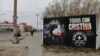 FILE - A person walks near a defaced painting of Argentina's Vice President Cristina Fernandez de Kirchner with the writing reading "All with Cristina" and "Thief, corrupt," in Rio Gallegos, Argentina October 10, 2023.