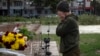 A servicewomen cries in Kherson, Ukraine, as she lays flowers to commemorate those killed in Russia's war on Ukraine, as the city of Kherson marks one year since Ukraine retook it from occupying Russian forces, Nov. 11, 2023.