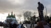 Ukrainian soldier Andriy Gomelyak pays his respect to Oleksandr Matsievskyi, who served with him in one unit and was executed by Russian troops in 2022, during the opening ceremony of Matsievskyi's statue in Nizhyn, Ukraine, Nov. 25, 2023. 