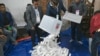 Election officials pour ballot papers from a ballot box for counting at a polling booth in Dhaka, Bangladesh, Jan. 7, 2024. 