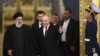 Russian President Vladimir Putin, center, welcomes Iranian President Ebrahim Raisi, left, for the talks at the Kremlin in Moscow, Dec. 7, 2023. (Pool Photo via AP)