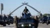 Iraqi Army soldiers drive their armored vehicles under the Victory Arch during a parade marking the Army Day in Baghdad, Jan. 6, 2024.