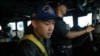 Lt. j.g. Bryan Nguyen stands watch on the bridge aboard the guided-missile destroyer USS Rafael Peralta in the Taiwan Strait, Nov. 2, 2023. 