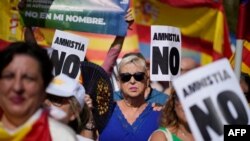 A protester holds 'No to amnesty' sign during a right-wing protest against plans to grant Catalan separatists an amnesty in order to form Spain's next government, in Barcelona on Oct. 8, 2023. 