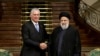 Iran's President Ebrahim Raisi, right, and his Cuban counterpart Miguel Diaz-Canel shake hands during a joint press conference at the presidential palace in Tehran, Dec. 4, 2023. (Photo by Iranian Presidency/AFP)