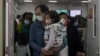 FILE - A man with a child walks out from a crowded holding room of a children's hospital in Beijing on Oct. 30, 2023.