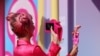 A fan takes a photo of a Barbie doll at the world premiere of the film "Barbie" in Los Angeles, California, July 9, 2023. 